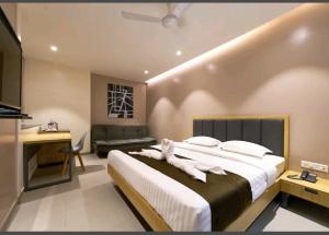 1 dormitorio con 1 cama grande y escritorio en Hotel Elite Inn- In Front Of Railway Station, en Kolhapur