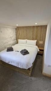 a bedroom with a white bed with towels on it at Grade II Lodge House 2 Bedroom in Trawsfynydd