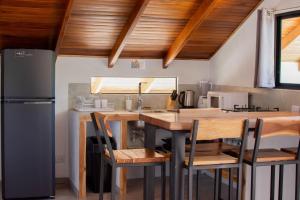 a kitchen with a table with chairs and a refrigerator at Leidy Mar Apartments in Santa Teresa Beach +45 photos