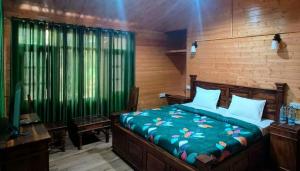 a bedroom with a bed with a green comforter at Pinewood Nirvana Jungle Resort Shoghi in Shimla