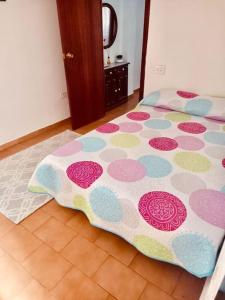 una cama con una manta de lunares en el suelo en Apartament Central Castellon!, en Castellón de la Plana