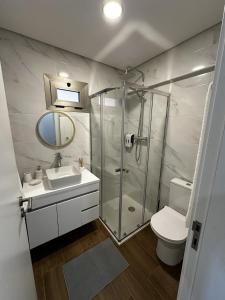 een badkamer met een douche, een wastafel en een toilet bij Quinta de Gandarem in Torre de Moncorvo