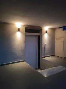 an empty room with a door and lights on the wall at DiaMar in Kallithea Halkidikis
