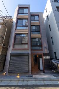 un edificio de apartamentos con un garaje delante de él en APB高円寺 en Tokio