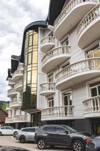 un edificio con coches estacionados frente a él en Olimp Hotel en Bukovel