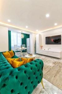 a living room with a green couch and a tv at Sika Luxury Apartment in Arad