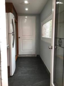 a hallway with a white door and a window at Bienvenido a Casa centro 152, a 2 min de consulado in Matamoros