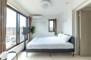 a bedroom with a bed and a large window at APB高円寺 in Tokyo