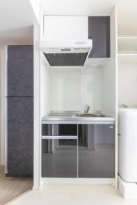 a kitchen with a sink and a refrigerator at APB高円寺 in Tokyo
