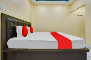 una camera da letto con un letto con cuscini rossi di OYO Flagship Heritage Farm Resort a Itwāri