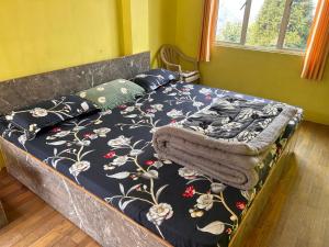 a bed with a blanket and pillows on it at Graham Hill’s Stay in Darjeeling