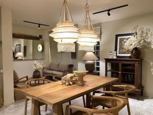 a living room with a wooden table and chandeliers at Sabaiday Guesthouse Nimman in Chiang Mai