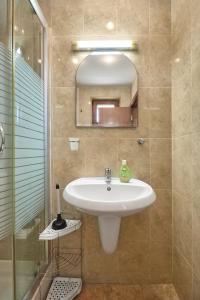 a bathroom with a sink and a shower and a mirror at Charming 2BD Guest House in Sozopol in Burgas City