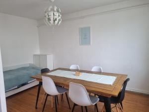 a dining room with a table and four chairs at 5 pièces traversant proche paris in Poissy