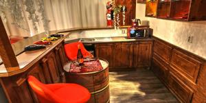 a kitchen with a barrel and a sink and a red chair at Ferrari wellness apartmán in Pardubice