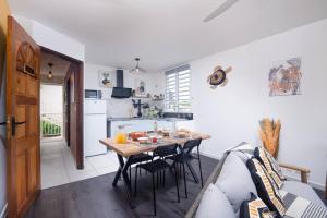 a kitchen and living room with a table and a couch at Le logis du passant in Rivière