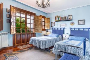 a bedroom with two beds and a window at Casa Montañesa in El Astillero
