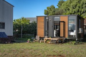 a tiny house sitting on top of a yard at Campbells Cottage - Farm Stay Victoria 