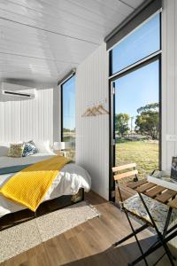 a bedroom with a bed and a large window at Campbells Cottage - Farm Stay Victoria 