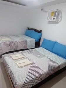 two beds sitting next to each other in a room at GRIN MCFLY INTERNATIONAL BEACHFRONT GUEST HOUSE in Fuerte