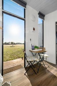 a room with a table and chairs and a large window at Campbells Cottage - Farm Stay Victoria 