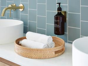 - Cesta de toallas en la encimera del baño con una botella de jabón en Green Valley Hotel en Mount Pritchard