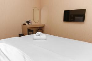 a bedroom with a bed with two towels on it at Aston Hotel in Aktau