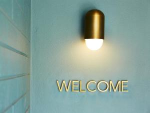 a light hanging on a wall with the welcome sign at Green Valley Hotel in Mount Pritchard