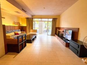 ein großes Wohnzimmer mit einem Sofa und einem TV in der Unterkunft Hua Hin Blue Lagoon-Pool Access in Cha-am