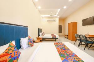 Cette chambre comprend un lit, une table et des chaises. dans l'établissement FabHotel Mint Park, à Hyderabad