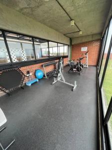 a gym with exercise equipment in a building with windows at Diua - Artistic and Bohemian apartment in Guatemala