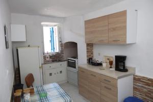 a kitchen with wooden cabinets and a counter top at Paraporti Rooms in Andros