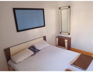 Dormitorio pequeño con cama y espejo en Hotel Trimurti, Dwarka, en Dwarka