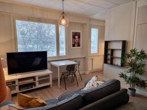 a living room with a couch and a flat screen tv at Studio Porin Otso, home away home in Pori city center in Pori