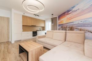 una sala de estar con un sofá y una mesa en Letnica - Seaside Apartments, en Gdansk