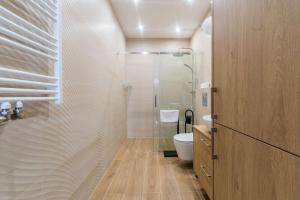 Un baño con ducha de cristal y un inodoro. en Letnica - Seaside Apartments, en Gdansk 23 fotos más
