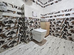 baño con aseo y papel pintado con animales en Zen Homestay en Cheog