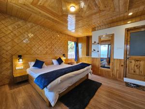 1 dormitorio con 1 cama grande en una habitación de madera en Zen Homestay en Cheog