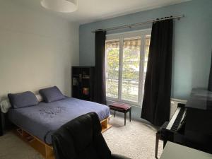 - une chambre avec un lit et une fenêtre dans l'établissement Logement en Hôtel Particulier - 3mn Paris et métro, à Boulogne-Billancourt