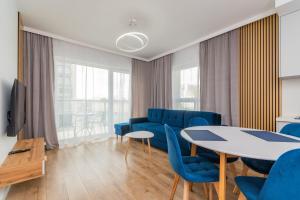 Una sala de estar con sillas azules y una mesa. en Letnica - Seaside Apartments, en Gdansk