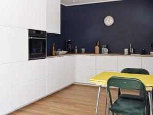 a kitchen with a table and a clock on the wall at Holiday home Vesterøy II in Rød