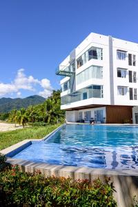 un edificio con piscina frente a un edificio en D' Elmer's Resort and Convention Hotel, en Dinadiwan