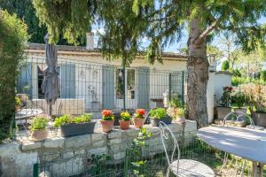 a garden with potted plants and a table and a tree at Appartement agréable en Provence in Saint-Rémy-de-Provence