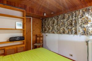 a bedroom with a green bed and a curtain at Loft in centro a Torre del Lago in Torre del Lago Puccini