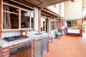 an outdoor kitchen with a stove and a patio at Loft in centro a Torre del Lago in Torre del Lago Puccini