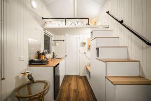 a tiny house with a staircase and a kitchen at Quiet Lake House In Winery in Flowerdale