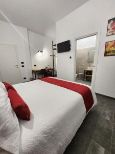 a bedroom with a large white bed with red pillows at Agriturismo Il Vivaio in Bergamo