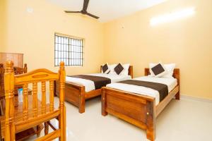 a bedroom with two beds and a window at Hotel Balaji Rameswaram in Rāmeswaram