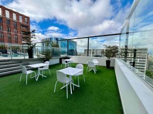 a balcony with tables and chairs on a building at New Modern Apartment with pool in Guatemala