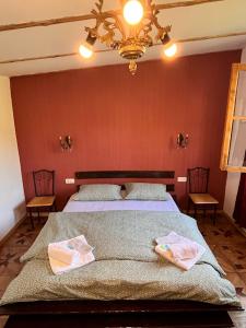 a bedroom with a bed with two towels on it at Villa Rbona in Khashuri